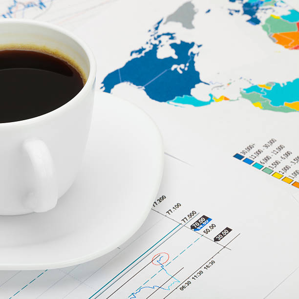 istock Coffee cup over world map and some charts 474337788