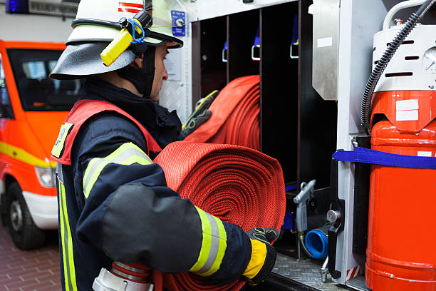 bombero encumbers un vehículo de emergencia de equipo de incendios - action fire department car men fotografías e imágenes de stock