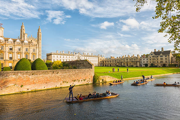 Punting in Cambridge Oxford, United Kingdom - October 27, 2013: Punting in Cambridge. In front view boats on the river with tourists, in background Kings Colledge, green grass and blue sunny sky. cambridgeshire photos stock pictures, royalty-free photos & images