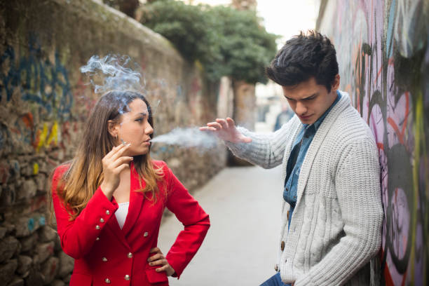 nonsmoker 男性、燻製器などの若い女性 - anti smoking ストックフォトと画像