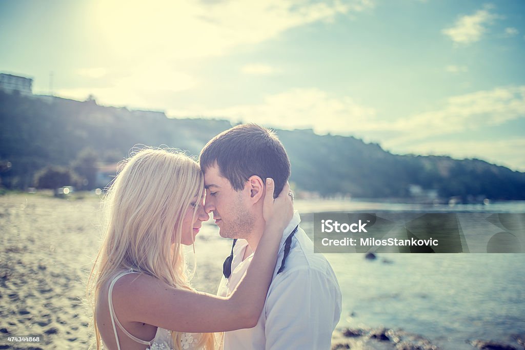 Just merried romance at the beach. Young married couple kissing  on the beach. Couple - Relationship Stock Photo