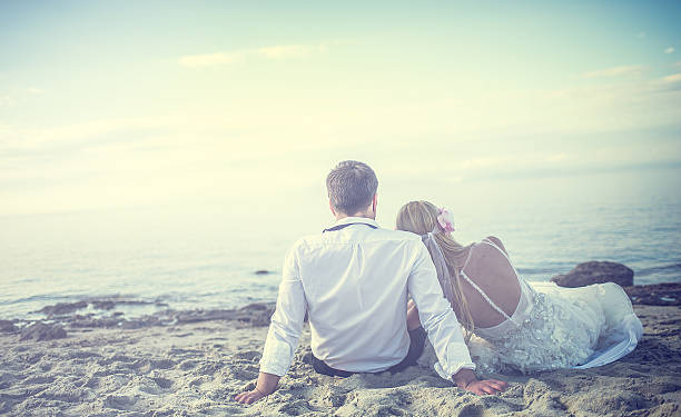 Just married hapy couple, bride and groom running  and open arms on the beach.
