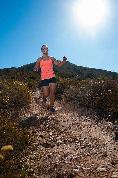 istock Blonde female trail runner running through a mountain landscape 474347536