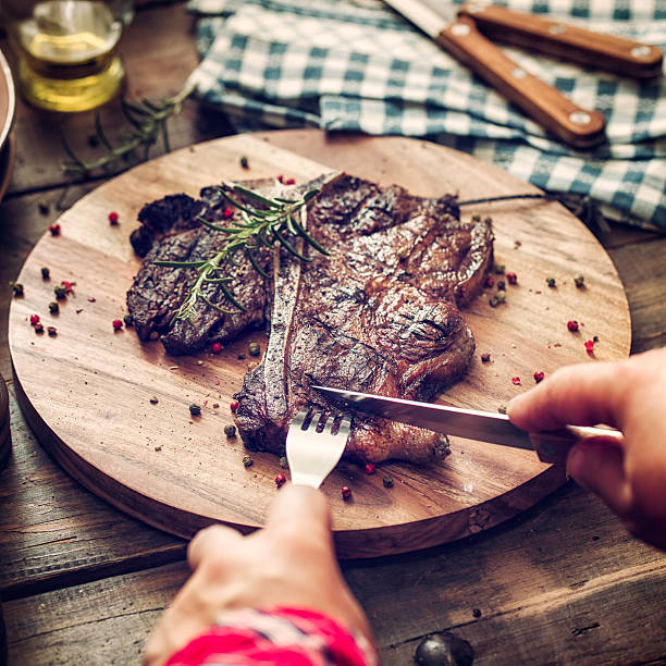istock Young Woman Eating Medium Roasted T-Bone Steak 474350004