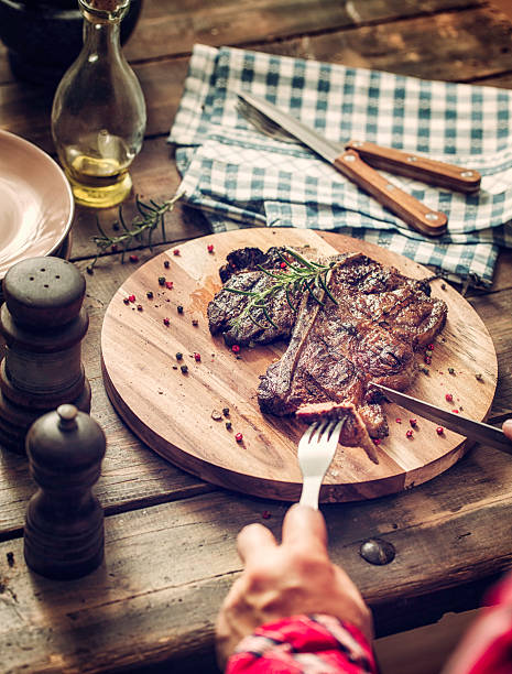 istock Young Woman Eating Medium Roasted T-Bone Steak 474350020