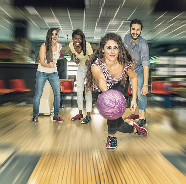 istock Young woman playing bowling with friends 474350080