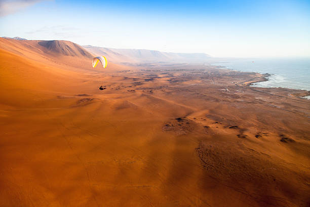 paragliders nas montanhas de iquique, chile - sand river stock-fotos und bilder