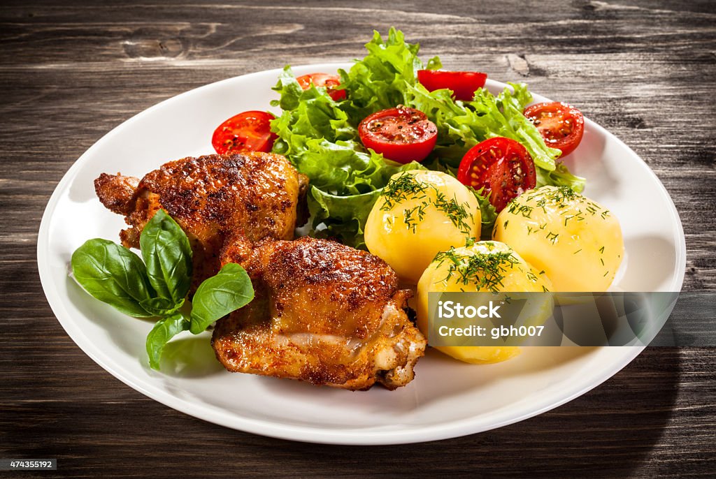 Roasted chicken legs, boiled potatoes and vegetables Roasted chicken legs and vegetables  2015 Stock Photo