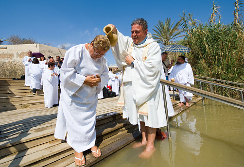 Yericho, Israel - October 15, 2014: A christian woman is being baptized by water during a baptism ritual at Qasr el Yahud near Yericho on the Jordan river