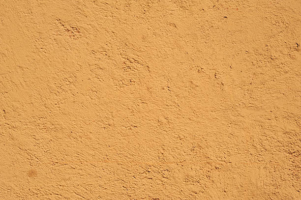 istock Texture of old wall covered with yellow stucco 474360024