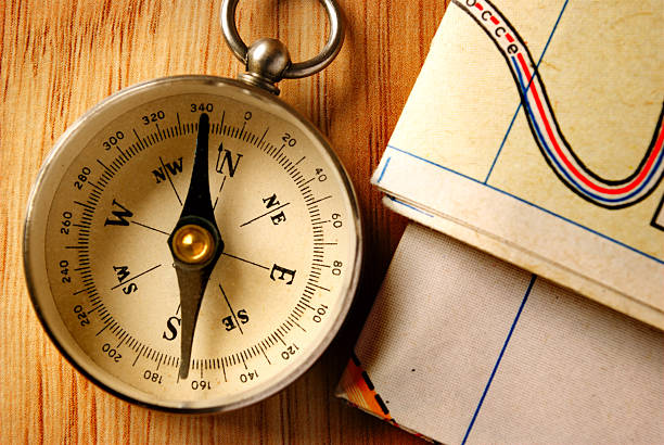 istock Vintage Compass on Wooden Table with Folded Maps 474360630