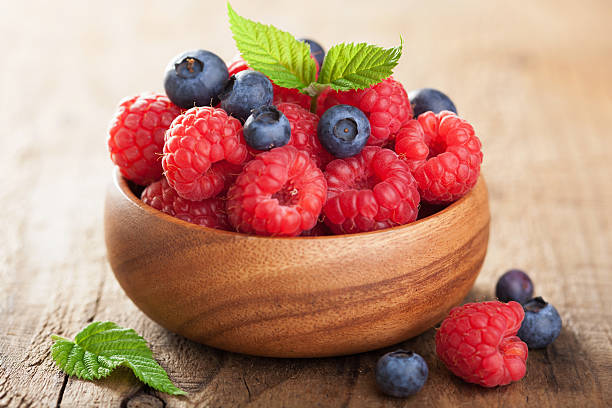 istock fresh berries raspberry blueberry in wooden bowl 474361322