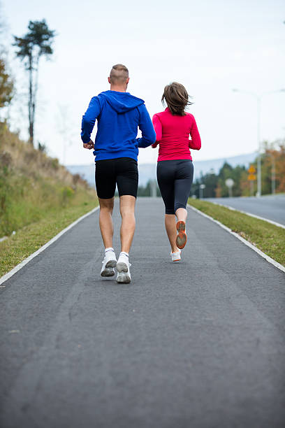 istock Woman and man jogging in park 474362030