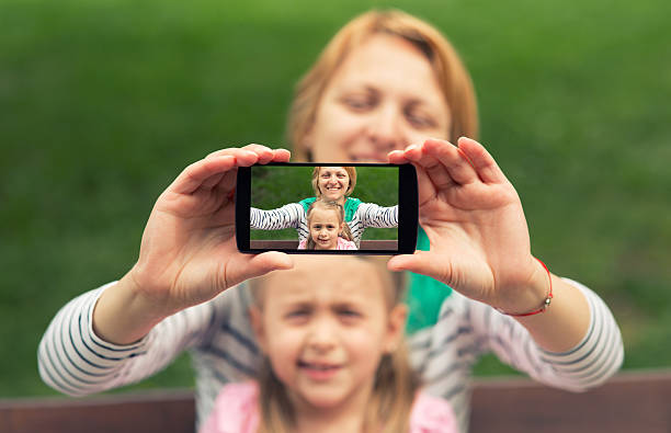 istock Mother and daughter making selfie 474362350
