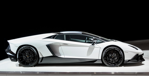 Amsterdam, The Netherlands - April 16, 2015: Lamborghini Aventador sports car on display during the 2015 Amsterdam motor show. The car is displayed on a white podium with a black background.