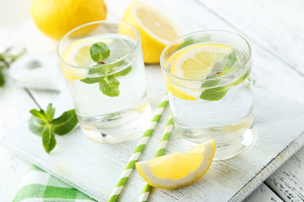 istock Fresh lemonade with lemon on white wooden background 474366946