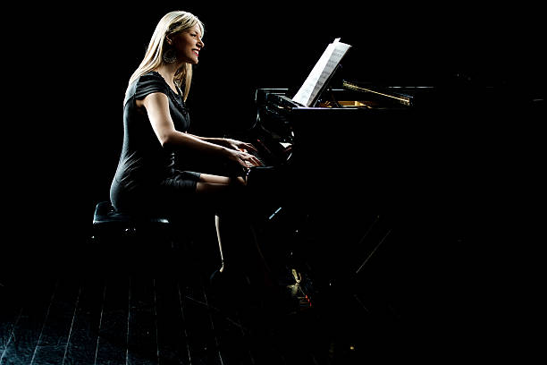 istock Smiling woman playing piano. 474368768