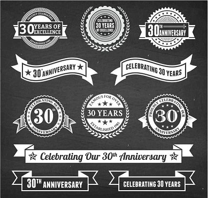 thirty year anniversary hand-drawn chalkboard royalty free vector background. This image depicts a black chalkboard with multiple anniversary announcement designs. There is chalk dust remaining on the chalkboard and the chalkboard texture serves a perfect backdrop for making the anniversary announcements look authentic and elegant.