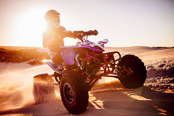 istock Quad biker in desert race with sun flare behind 474377764