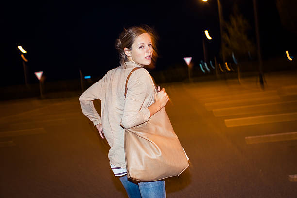 Scared young woman running from her pursuer in a deserted parking lot