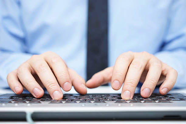 empresário em camisa azul digitando no teclado de computador - shirt and tie typing communication part of - fotografias e filmes do acervo