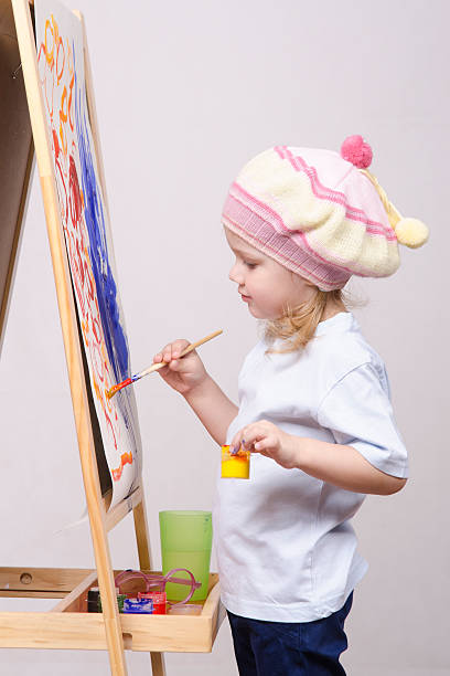 istock Girl artist paints on canvas 474384473
