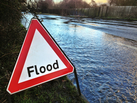 iphone shot. Flood sign by the side of a flooded road in the south of England.