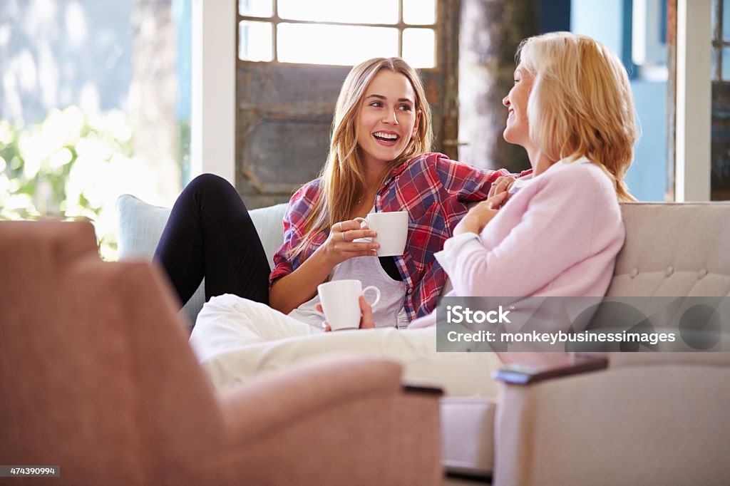 Mature Mother With Adult Daughter Relaxing On Sofa At Home Mother Stock Photo
