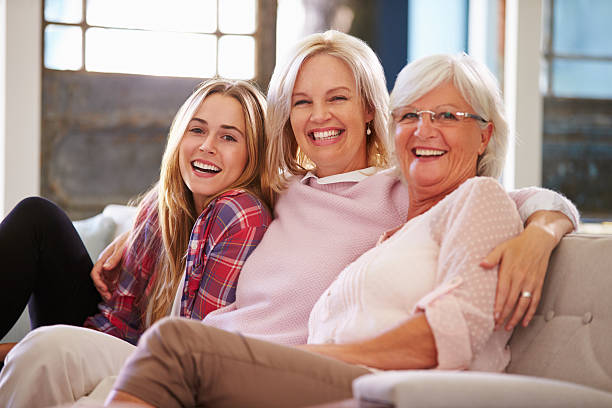 abuela con madre e hija descansando en el sofá adultos - grandparent adult smiling looking at camera fotografías e imágenes de stock