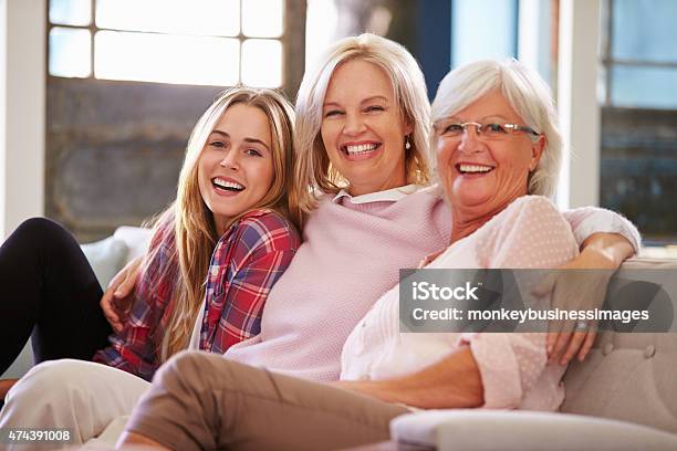 Grandmother With Mother And Adult Daughter Relaxing On Sofa Stock Photo - Download Image Now