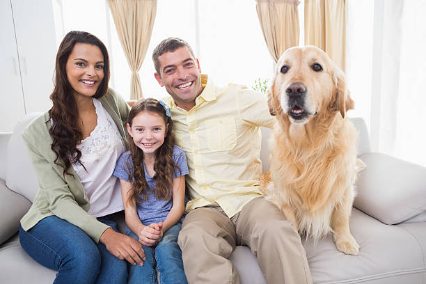 istock Family sitting with dog on sofa 474395078