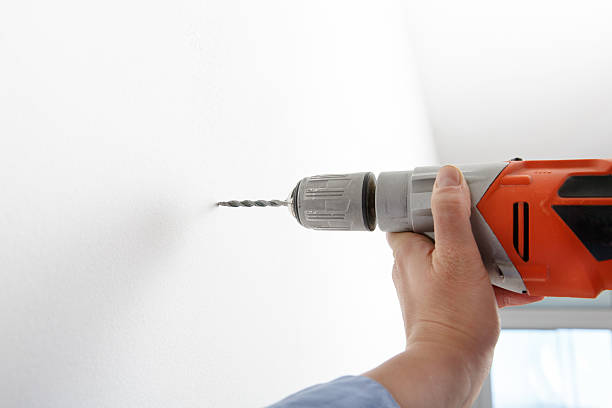 istock Worker drilling hole with electric power driller 474395276