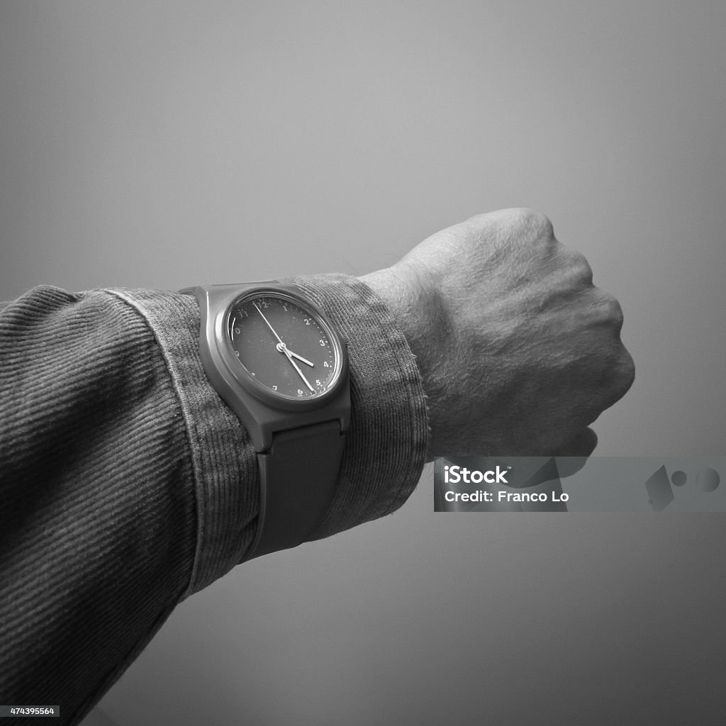 Arm who wears wristwatch. Arm who wears wristwatch, on the sleeve of his shirt,isolated on grey background. 2015 Stock Photo