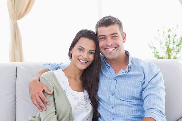 istock Happy loving couple sitting on sofa 474395630