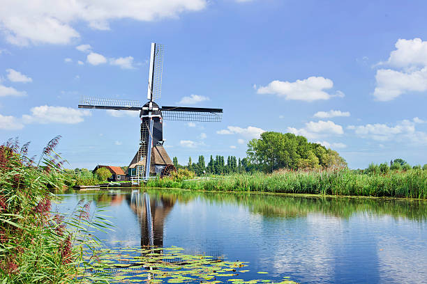 istock Ancient wooden windmill mirrored in canal on summerday, Netherlands 474395808