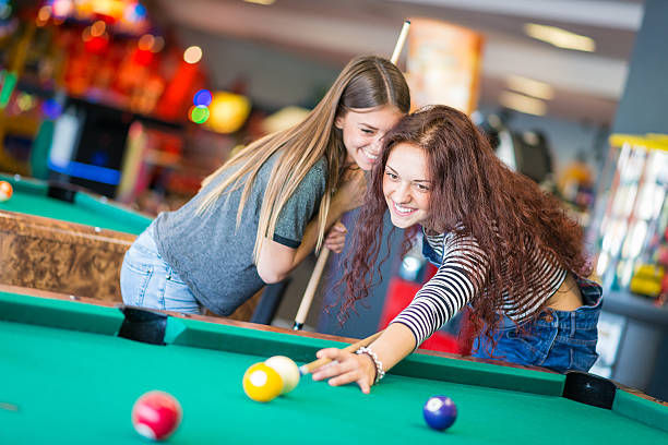 istock Two girls friends playing pool 474395974