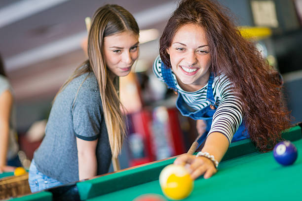 istock Two girls friends playing pool 474395978