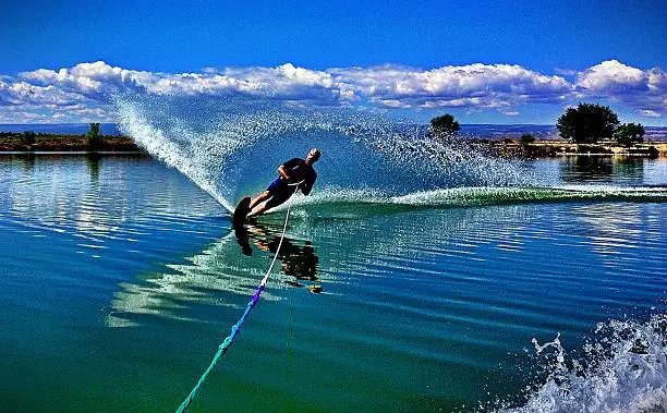 MobileStock capture of a 50 yr. old man slalom waterskiing on Sweitzer Lake in Delta, Colorado. He is carving the water with his ski as he makes a turn, creating a "rooster tail". Shot on an iPhone 4s and edited with Camera+ and PhotoToaster.