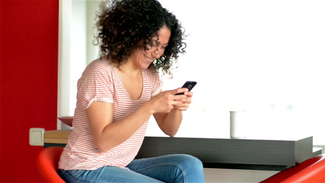 DOLLY: Young woman texting with smart phone at home
