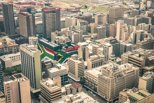 Close up detail of skyscrapers the business district of Johannesburg - Aerial view of modern buildings of the skyline in South Africa biggest city with southafrican flag painted on structure walls