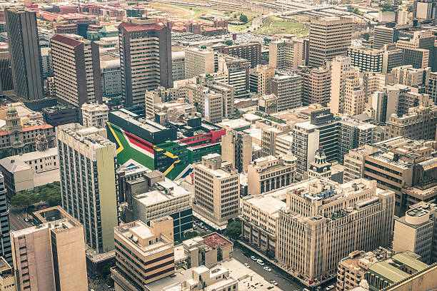 Close up detail of skyscrapers the business district of Johannesburg Close up detail of skyscrapers the business district of Johannesburg - Aerial view of modern buildings of the skyline in South Africa biggest city with southafrican flag painted on structure walls johannesburg photos stock pictures, royalty-free photos & images