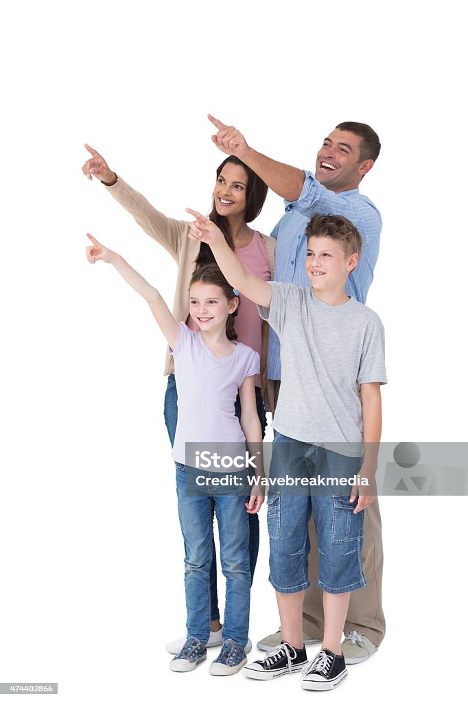 Family of four pointing at copy space Happy family of four pointing at copy space over white background Family Stock Photo