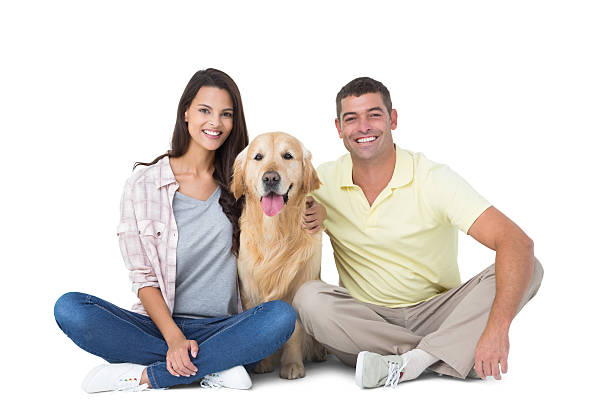 istock Happy couple with dog sitting over white background 474403188