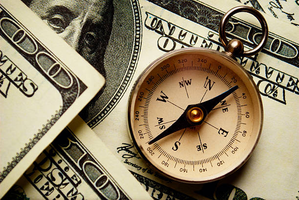 Magnetic compass on US dollar notes stock photo