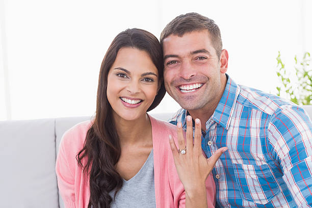 istock Happy young woman showing ring while sitting with man 474405310