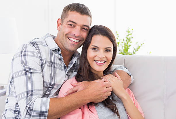 istock Happy man embracing woman on sofa 474405430
