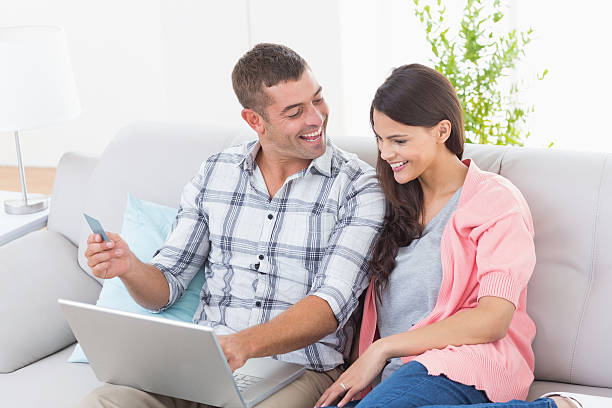 istock Couple shopping online on laptop using credit card 474405568