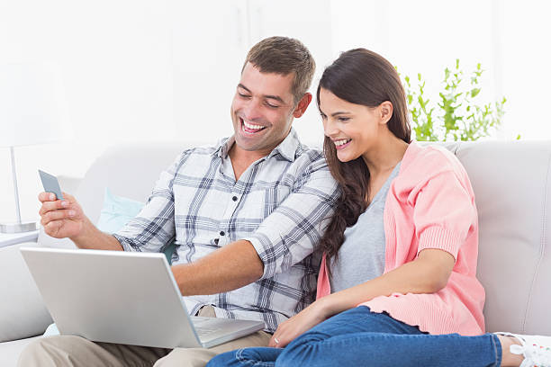 istock Couple shopping online through laptop using credit card 474405584