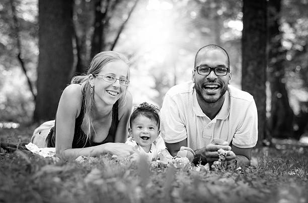 счастливый interracial семья, наслаждаясь день в парке. - adoption family multi ethnic group human teeth стоковые фото и изображения