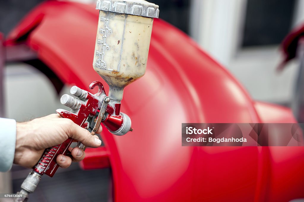 Primer plano de la pistola de aerosol de pintura rojo pintura de un coche - Foto de stock de Pintar libre de derechos